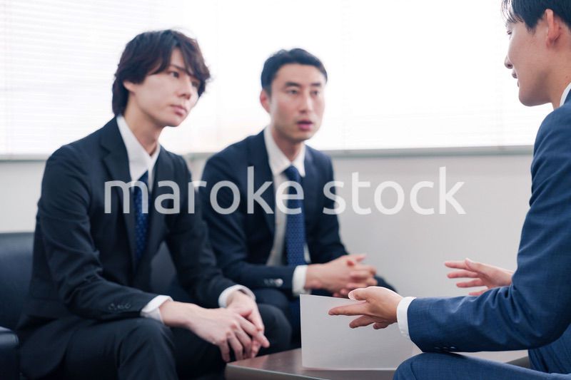 得意先と商談をするスーツを着たビジネスマン