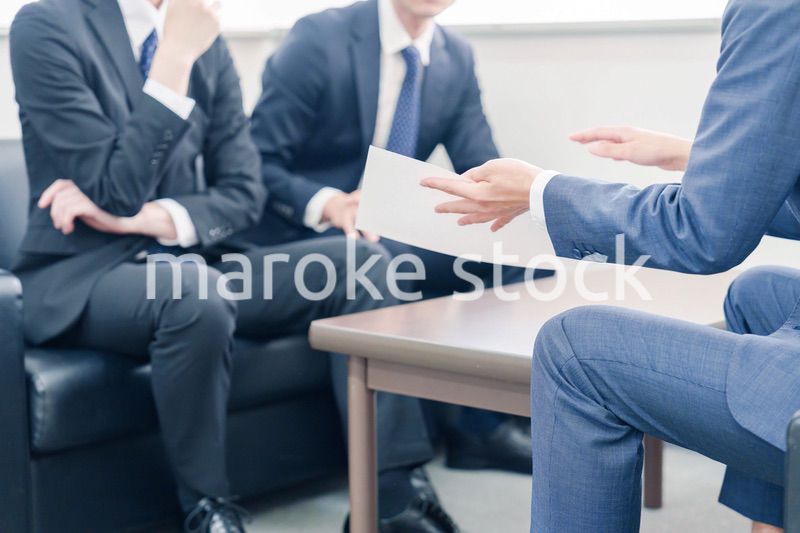 得意先と商談をするスーツを着たビジネスマン