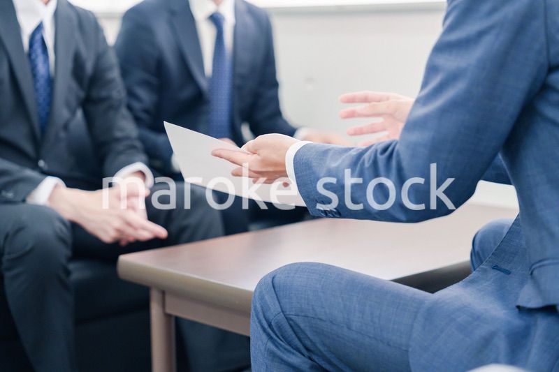 得意先と商談をするスーツを着たビジネスマン