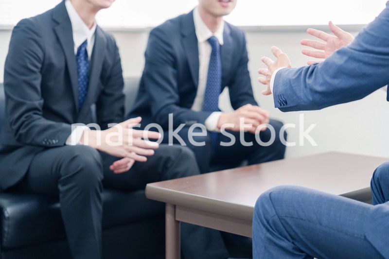 得意先と商談をするスーツを着たビジネスマン