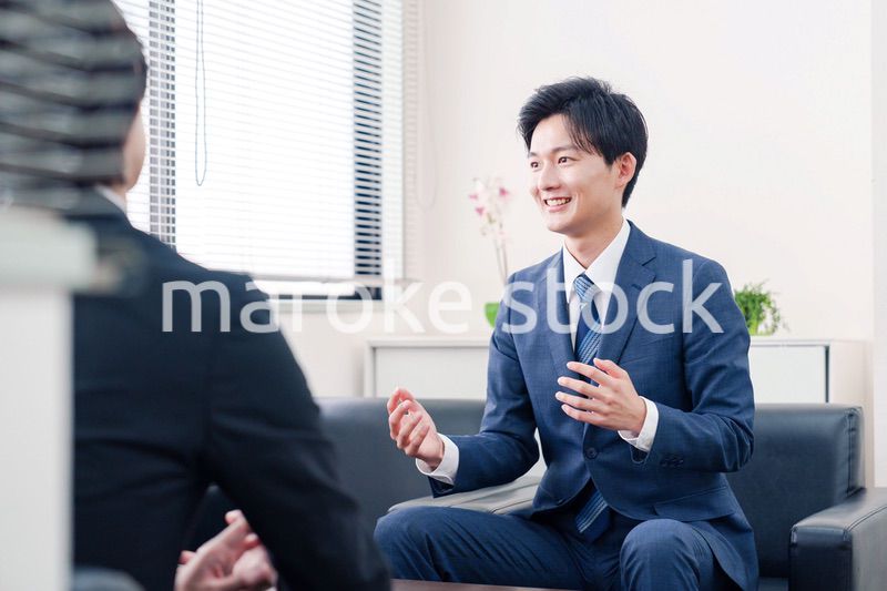 得意先と商談をするスーツを着たビジネスマン