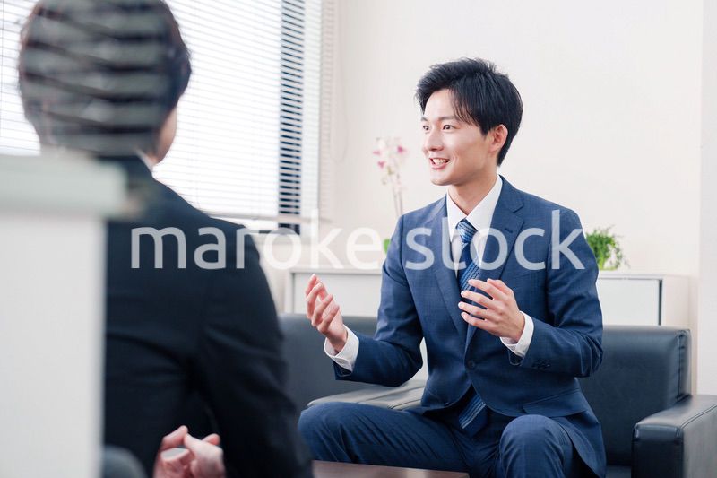 得意先と商談をするスーツを着たビジネスマン