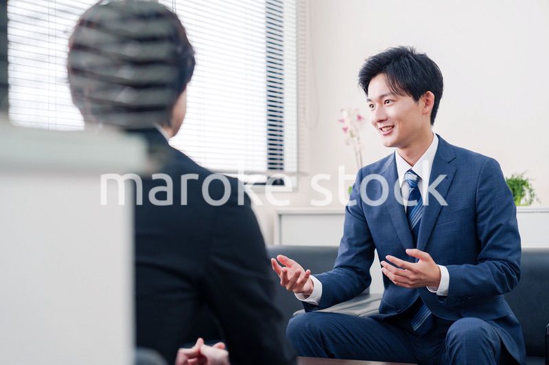 得意先と商談をするスーツを着たビジネスマン