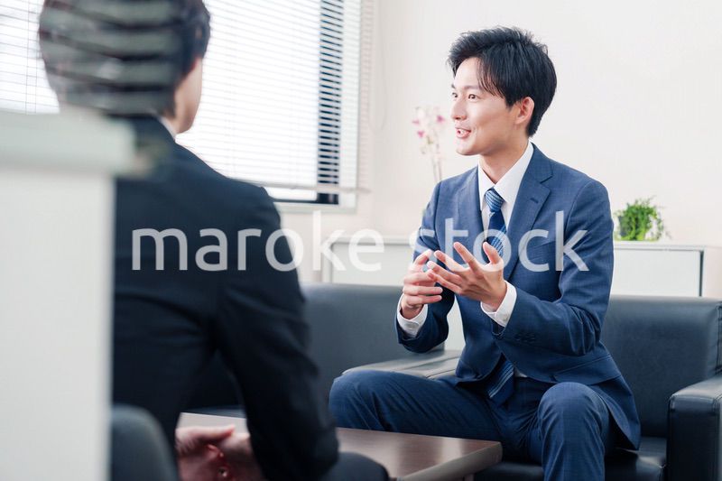 得意先と商談をするスーツを着たビジネスマン