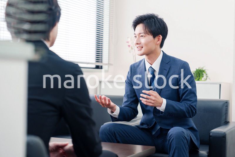 得意先と商談をするスーツを着たビジネスマン