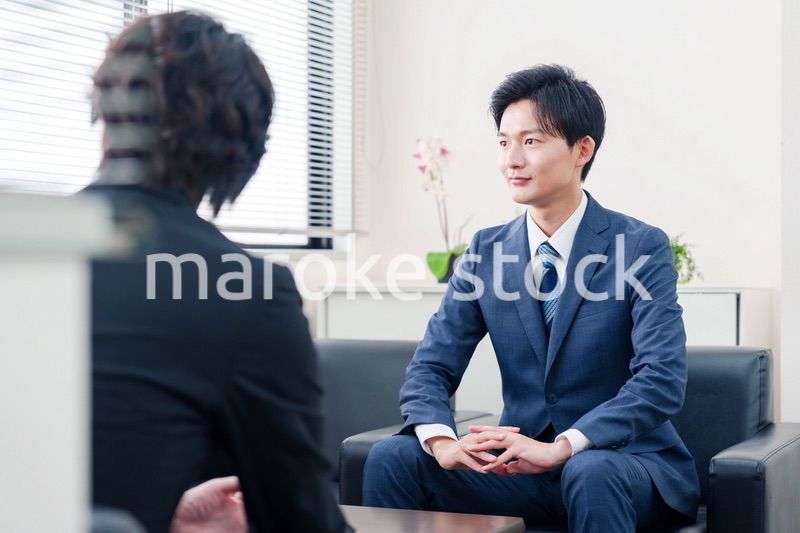 得意先と商談をするスーツを着たビジネスマン