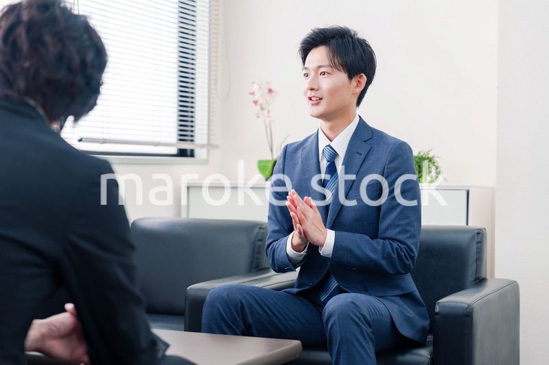 得意先と商談をするスーツを着たビジネスマン