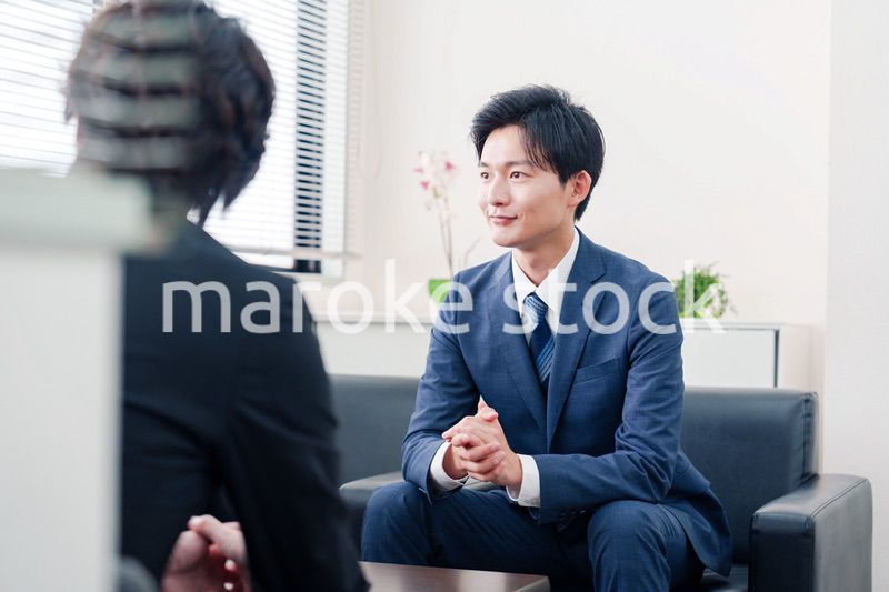 得意先と商談をするスーツを着たビジネスマン