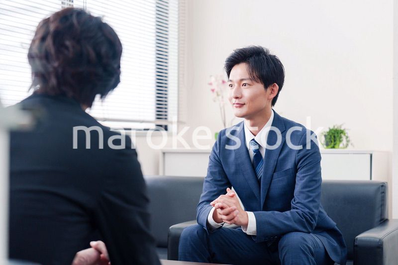 得意先と商談をするスーツを着たビジネスマン