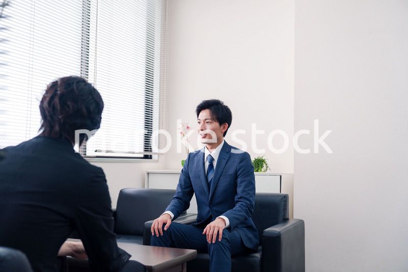 得意先と商談をするスーツを着たビジネスマン