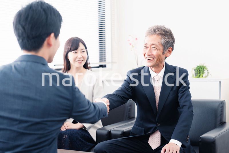 契約が成立し握手をするビジネスパーソン