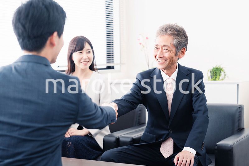 契約が成立し握手をするビジネスパーソン