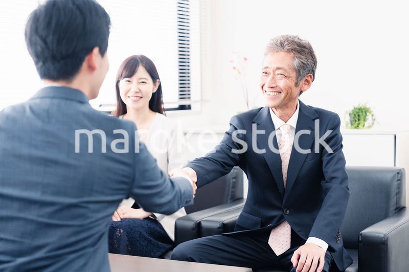 契約が成立し握手をするビジネスパーソン