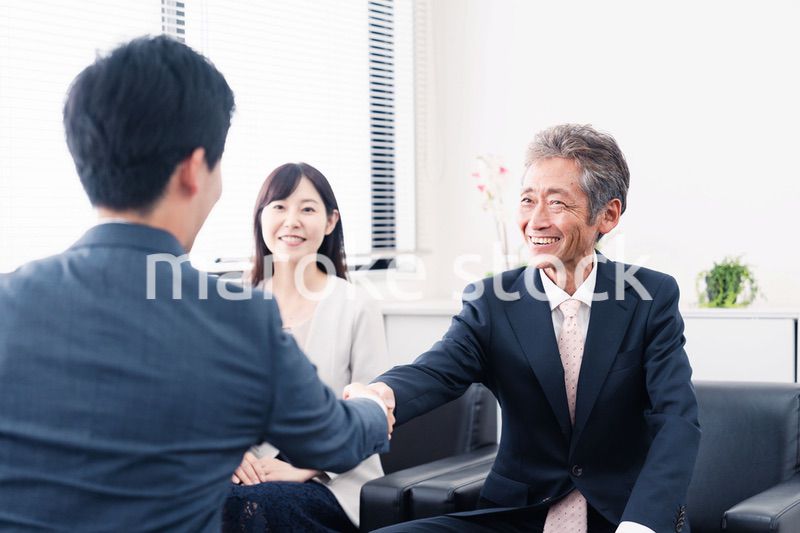 契約が成立し握手をするビジネスパーソン