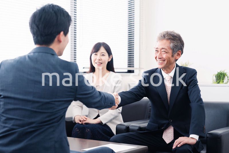 契約が成立し握手をするビジネスパーソン