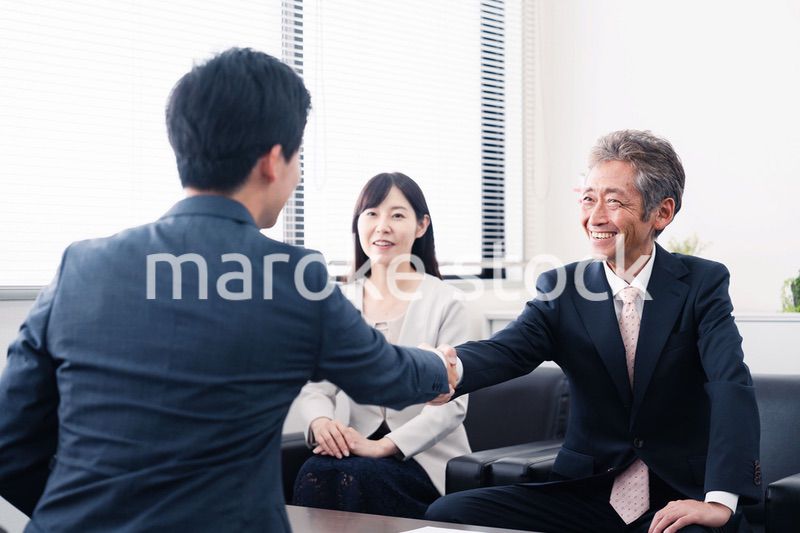 契約が成立し握手をするビジネスパーソン