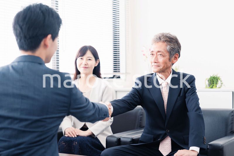 契約が成立し握手をするビジネスパーソン