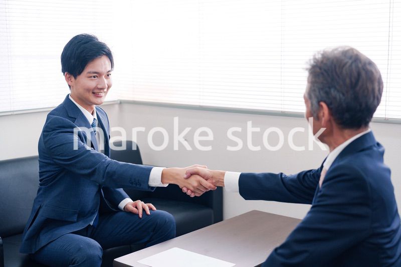 得意先と握手をするビジネスマン