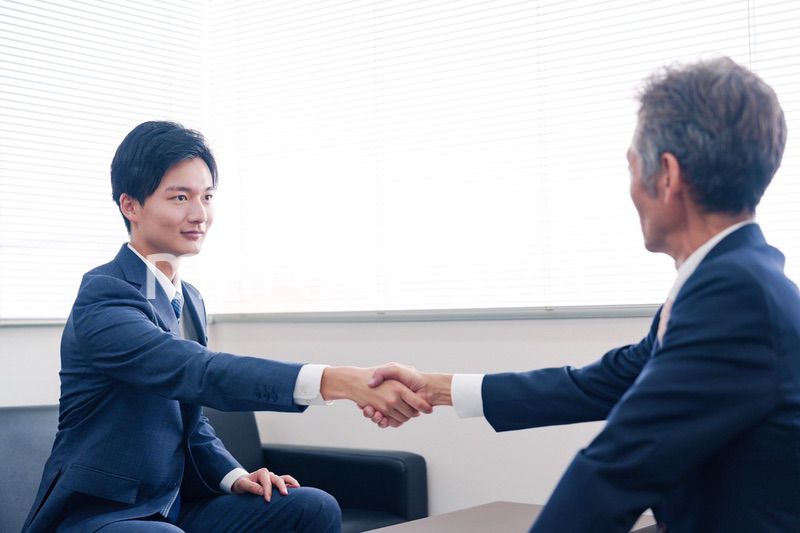 得意先と握手をするビジネスマン
