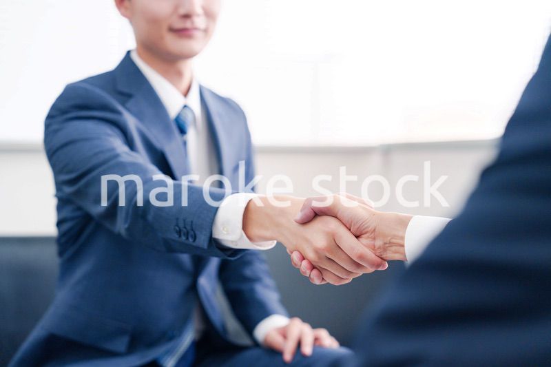 得意先と握手をするビジネスマン