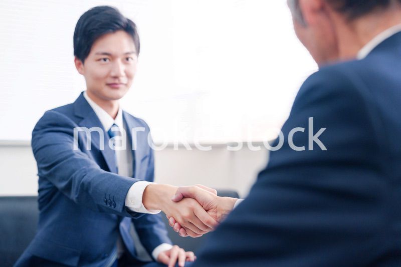 得意先と握手をするビジネスマン