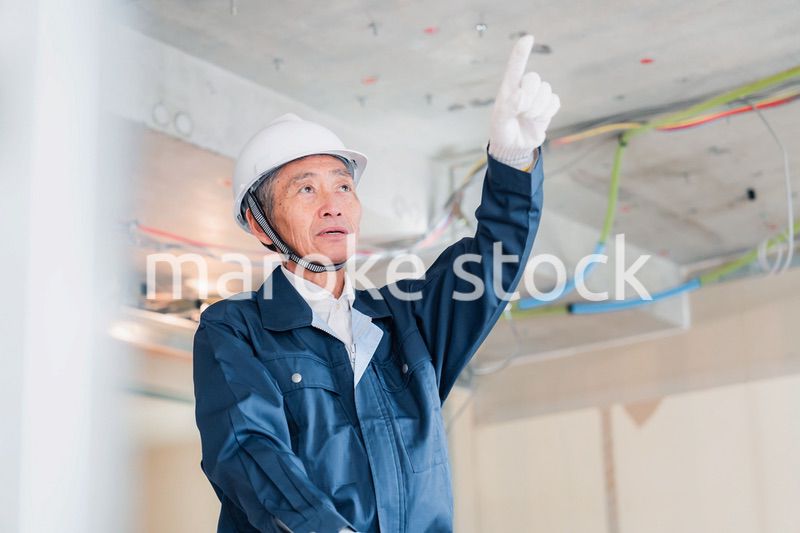 工事中の現場で指差し確認をする職人