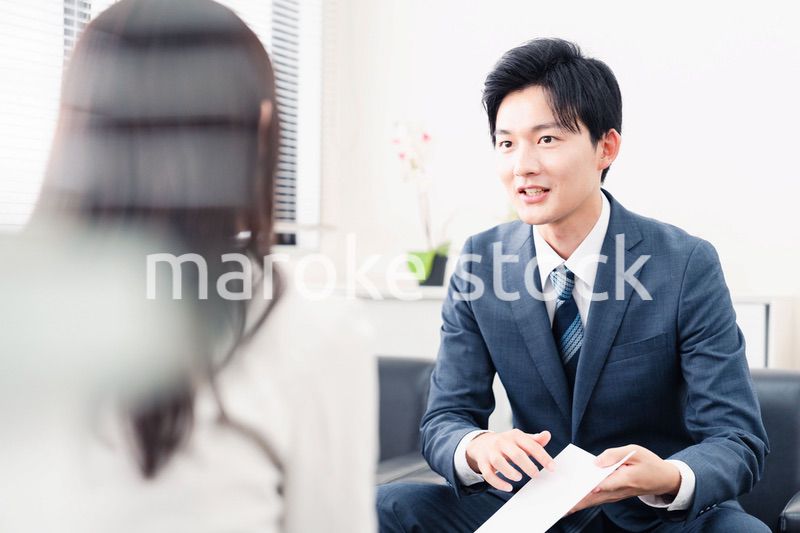 書類を提示する営業マン