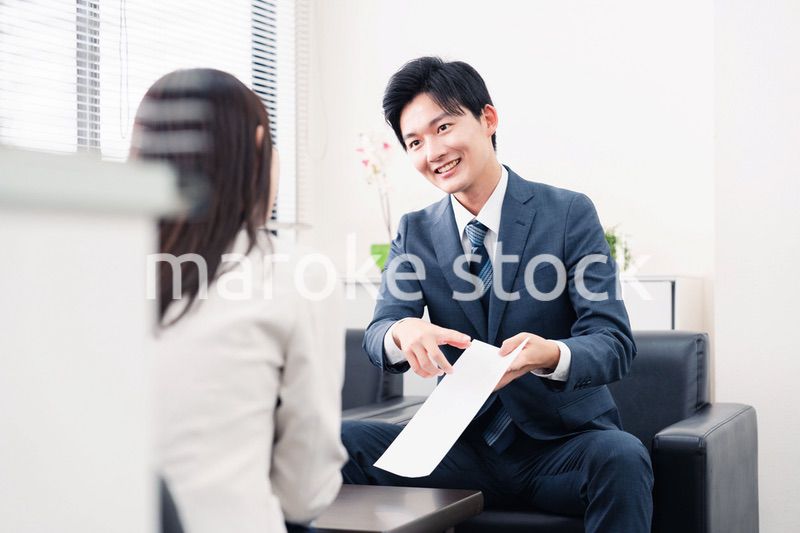 書類を提示する営業マン