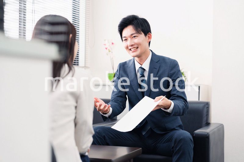 書類を提示する営業マン