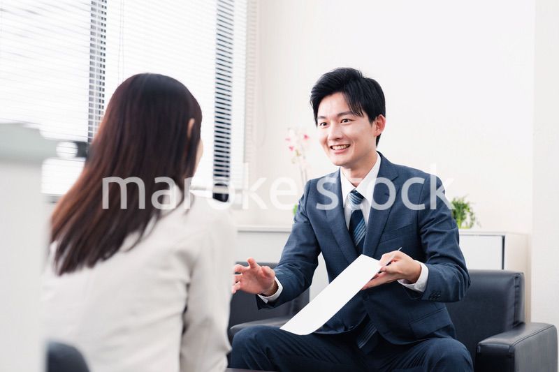 書類を提示する営業マン