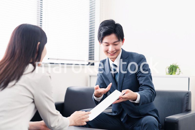 書類を提示する営業マン
