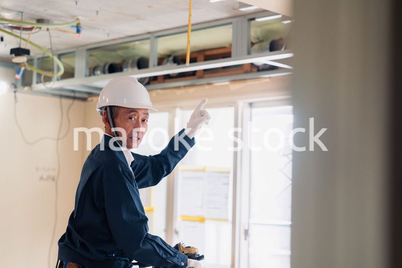 工事中の現場で指差し確認をする職人