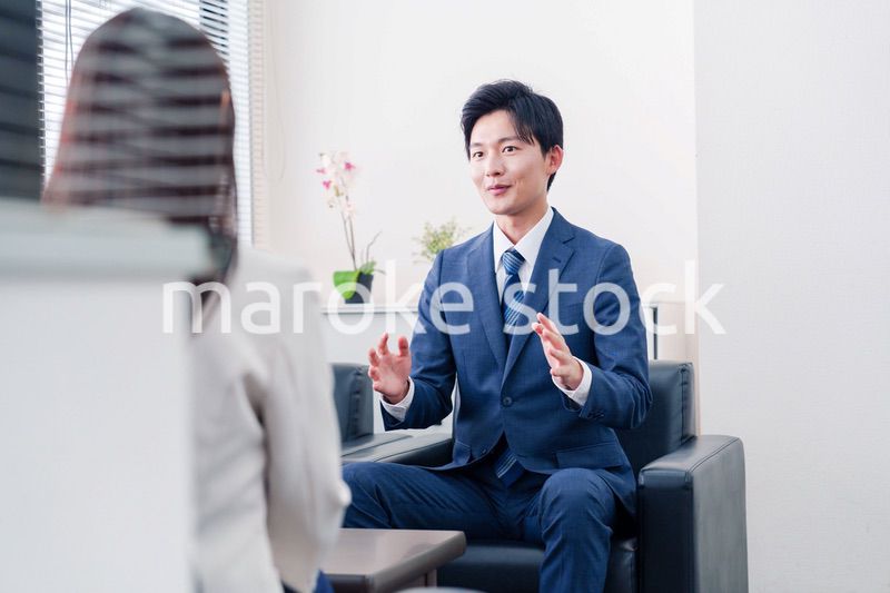 笑顔で得意先と商談をする営業マン