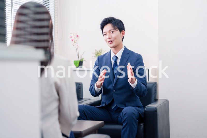 笑顔で得意先と商談をする営業マン