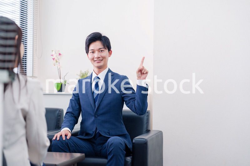 笑顔で得意先と商談をする営業マン