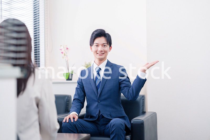 笑顔で得意先と商談をする営業マン