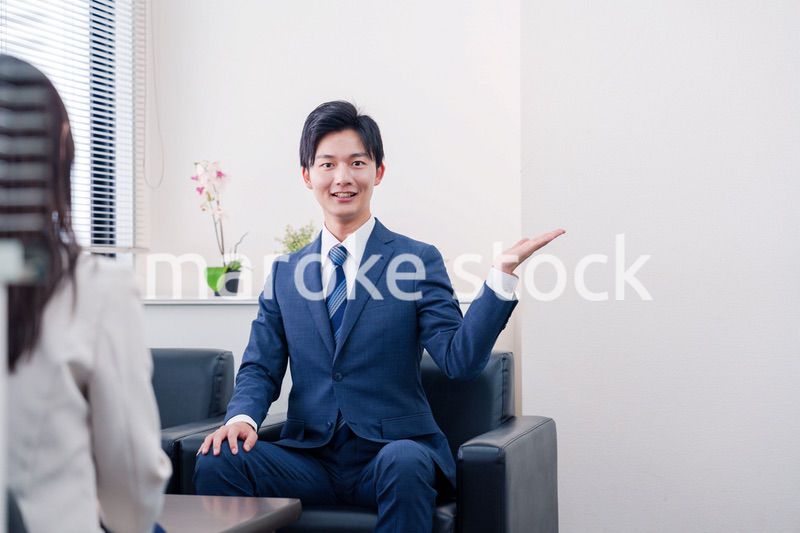 笑顔で得意先と商談をする営業マン