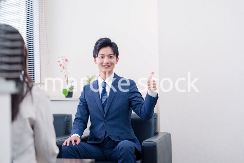 笑顔で得意先と商談をする営業マン