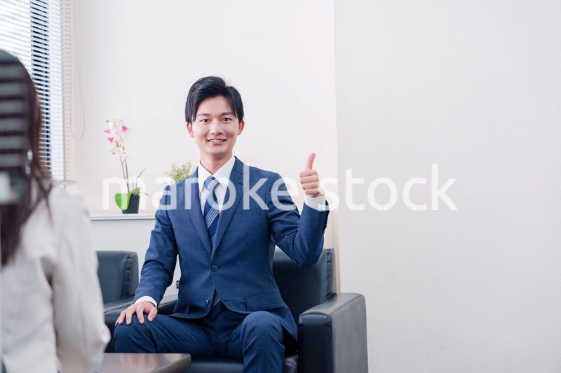 笑顔で得意先と商談をする営業マン