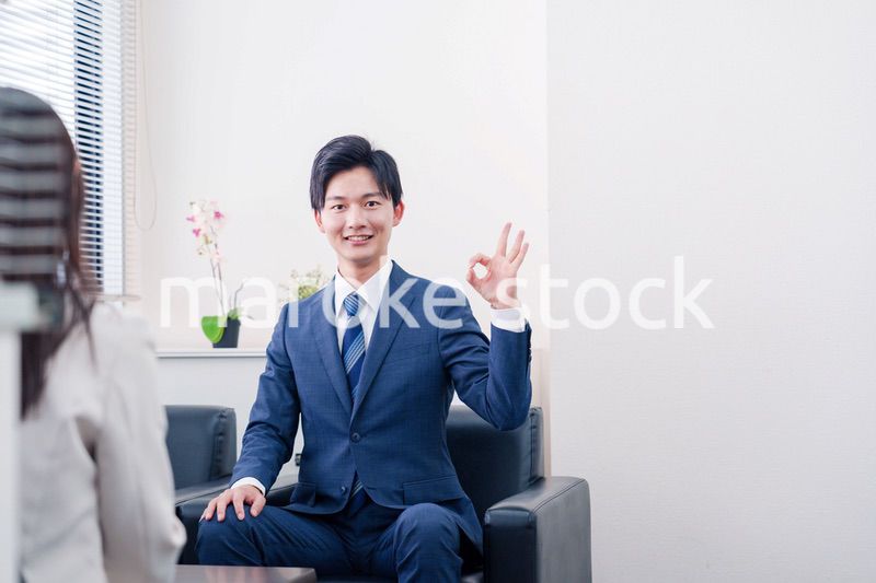 笑顔で得意先と商談をする営業マン