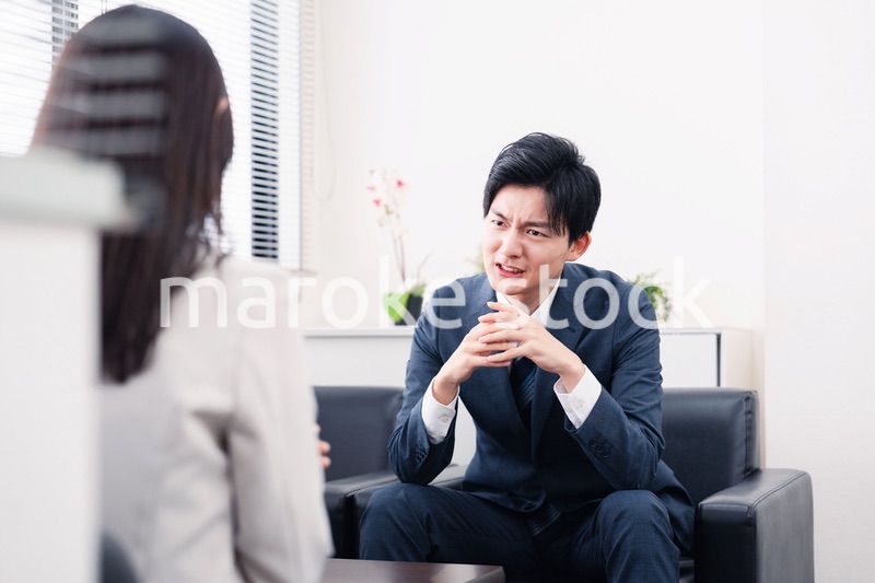商談で厳しい表情を見せるビジネスマン