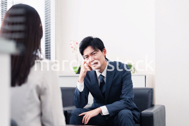 商談で厳しい表情を見せるビジネスマン