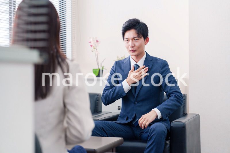 笑顔で得意先と商談をする営業マン