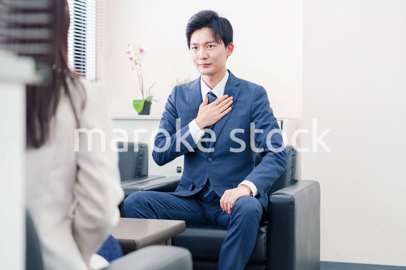 笑顔で得意先と商談をする営業マン