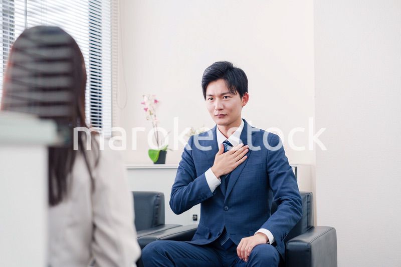 笑顔で得意先と商談をする営業マン