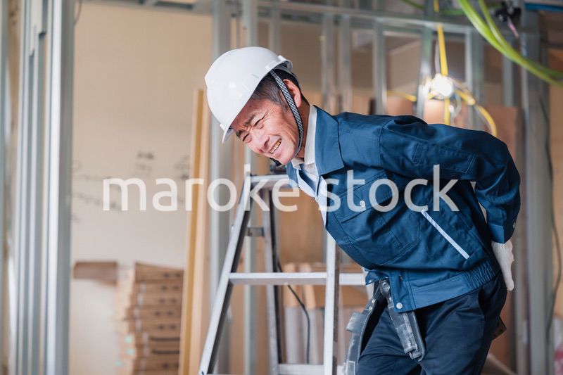 現場で腰を痛める大工