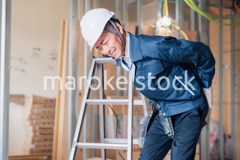 現場で腰を痛める大工