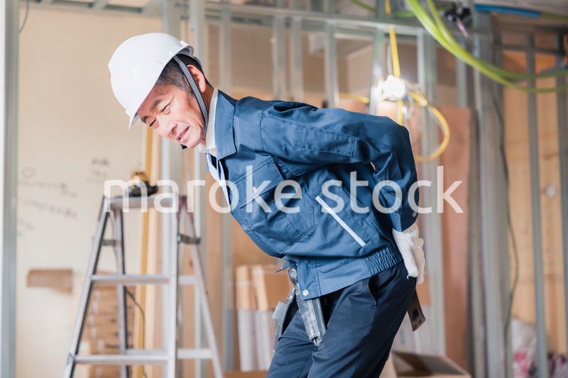 現場で腰を痛める大工