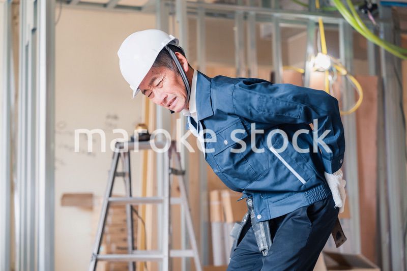 現場で腰を痛める大工