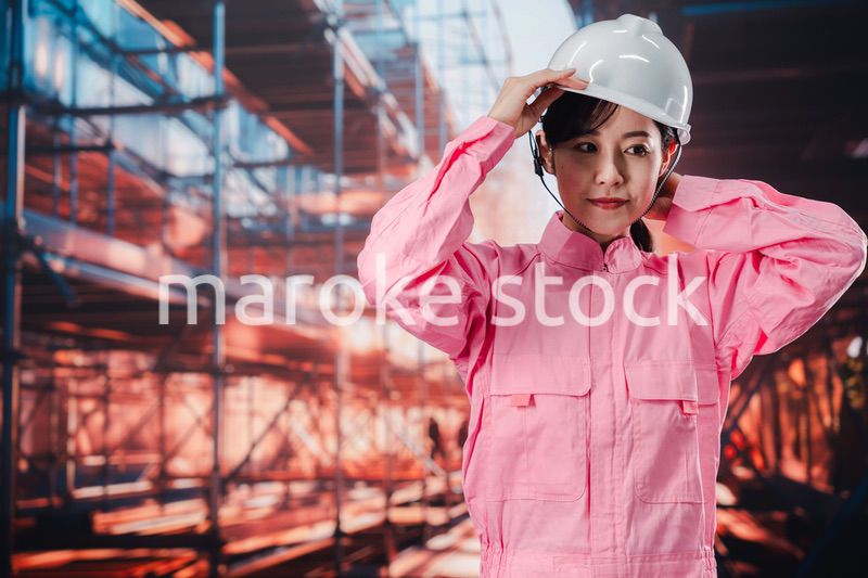 建設現場でヘルメットを被る女性